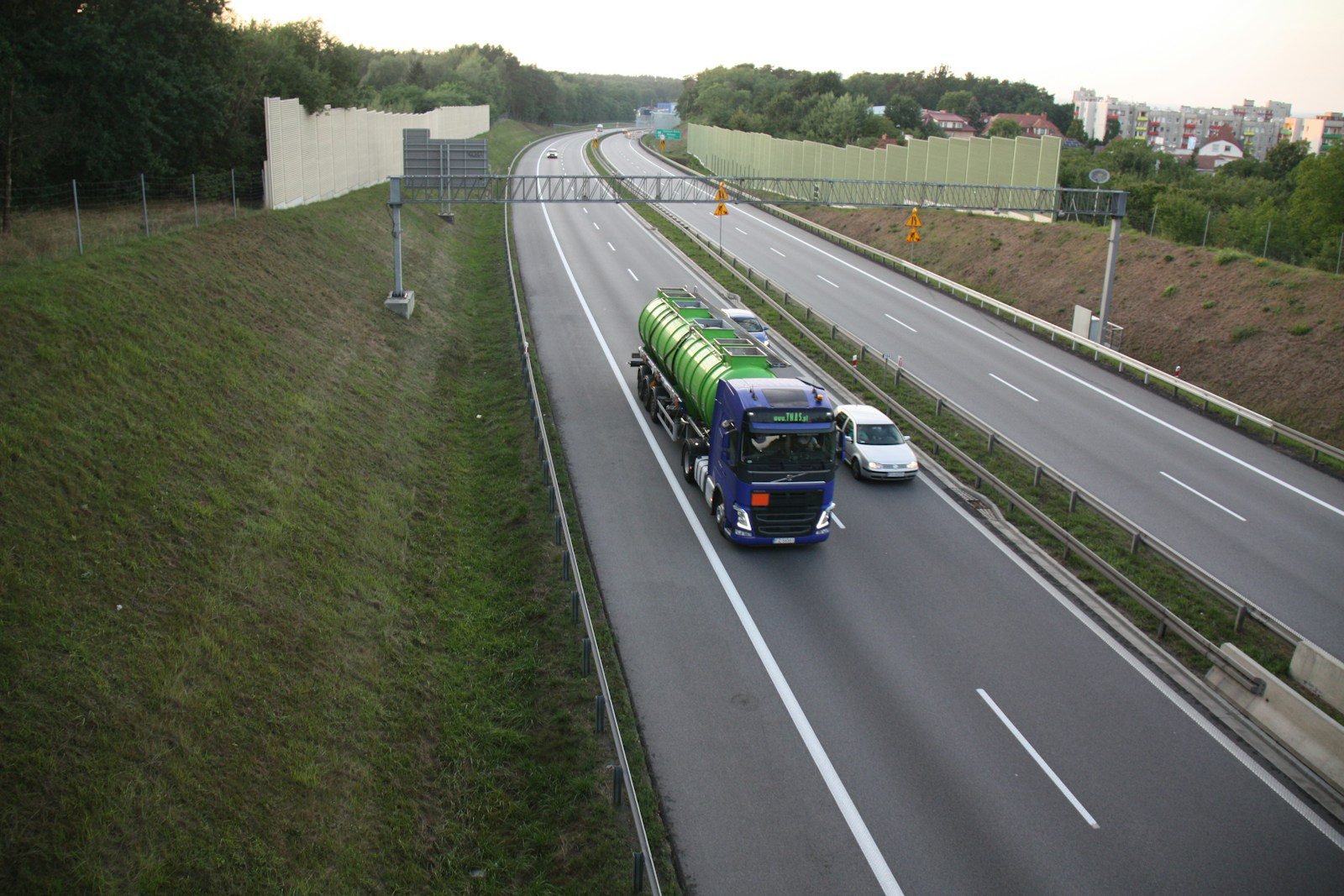 a green and blue truck driving down a highway