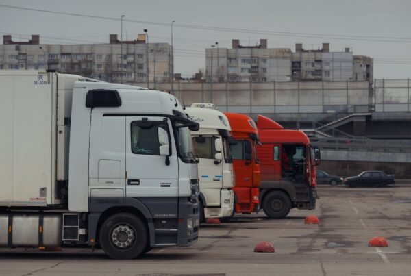 Trucks are parked in a row in a parking lot.