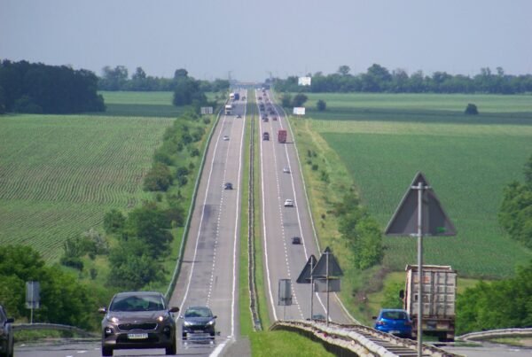 a long highway with cars driving down it